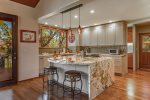The gourmet chefs kitchen has granite waterfall countertops, a large center island, copper sink, RO water system, KitchenAid gas range and microwave and a dual-zone wine refrigerator